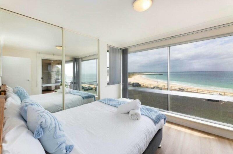 Master bedroom with large front window showcasing incredible ocean views