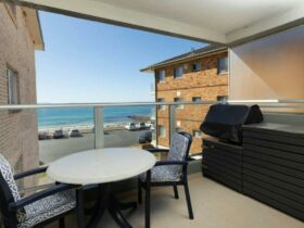 Balcony with 2 seater setting, BBQ and gorgeous beach views