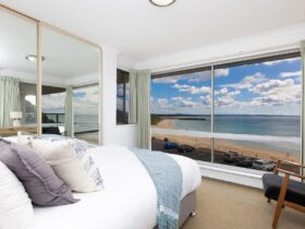 Coastal styled bedroom with Queen bed and panoramic beach views