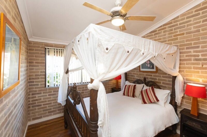 Master bedroom with 4 post bed with canopy, wooden ceiling fan with light