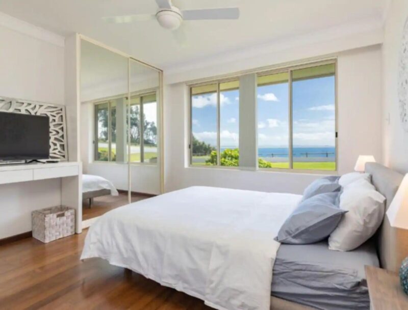 Bedroom with ceiling fan, mirrored built in wardrobe, TV, ocean views