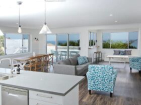 Modern, coastal styled living and dining areas leading on to balcony