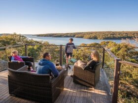 A family enjoying the view from the balcony of Hilltop Cottage in Royal National Park. Photo: John
