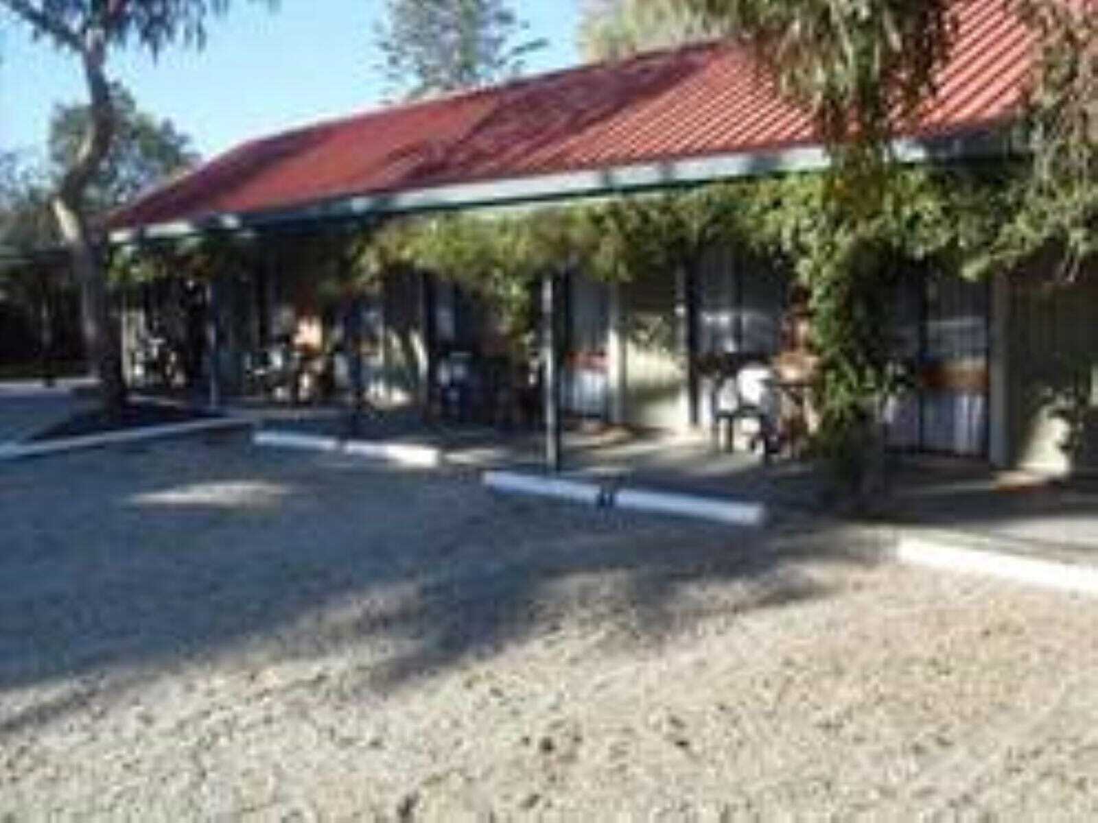Outside of the Jolly Swagman, car park and vines out the front of the building
