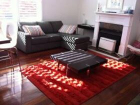 Living Room, Black lounge, red rug, fireplace