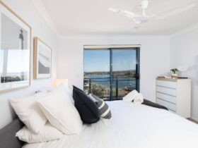 Master bedroom with King bed, balcony access, lake views, ceiling fan and TV