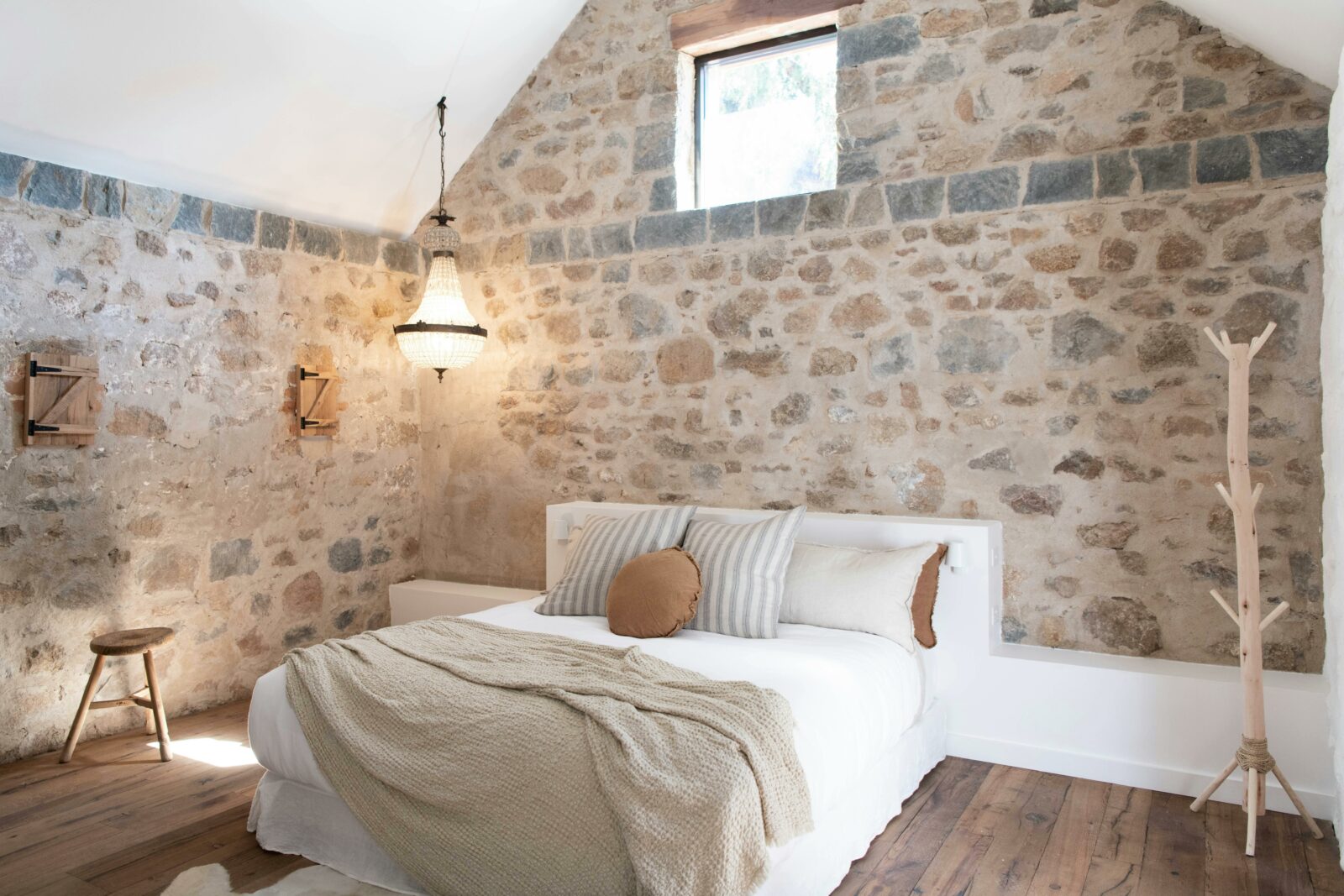Beautiful bedroom room with stone walls and high ceiling.