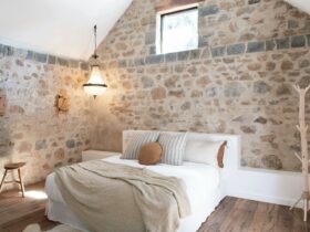 Beautiful bedroom room with stone walls and high ceiling.