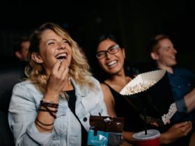 Ladies laughing in a cinema eating popcorn