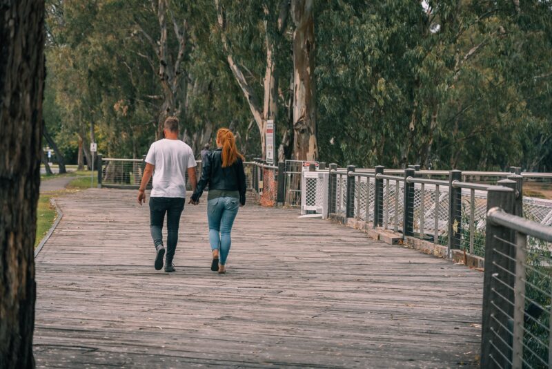Couple walking on wooden boardwalk