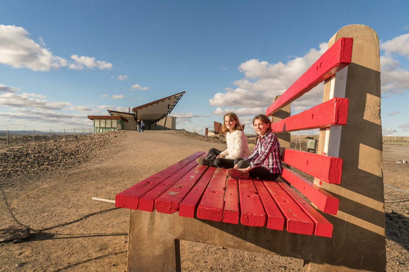 Children sitting on the Big Bench located at the Line of Lode Memorial in Broken Hill