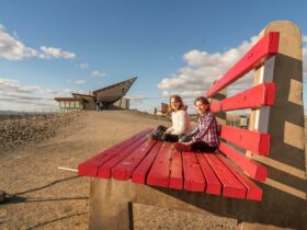 Children sitting on the Big Bench located at the Line of Lode Memorial in Broken Hill