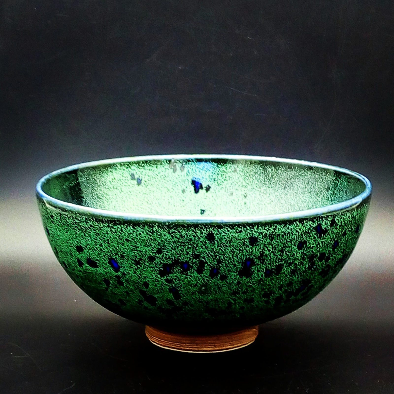 Bowl, made on the potters wheel and finished in a green glaze with glassy blue spots.