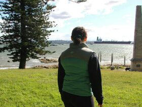 Girl looking out past Captain Cook Monument in Kurnell, Kamay Botany Bay National Park. Photo