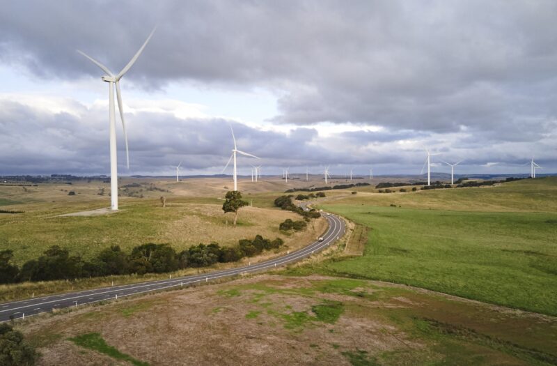 landscape shot of wind farm with numerous turbines off in distance