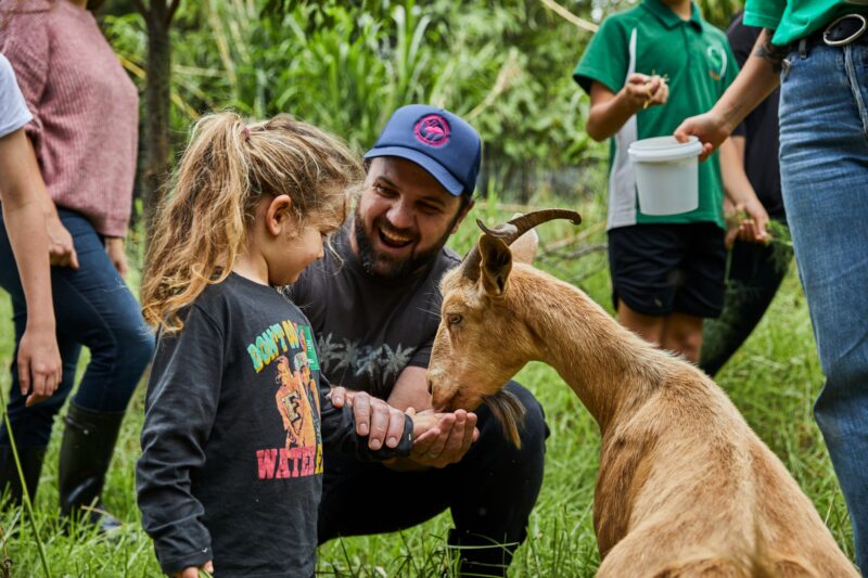 Father and daughter and feeding goat at the Green Connect Farm