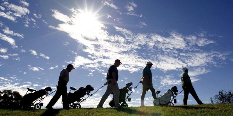4 Golfers walking with the sun behind them