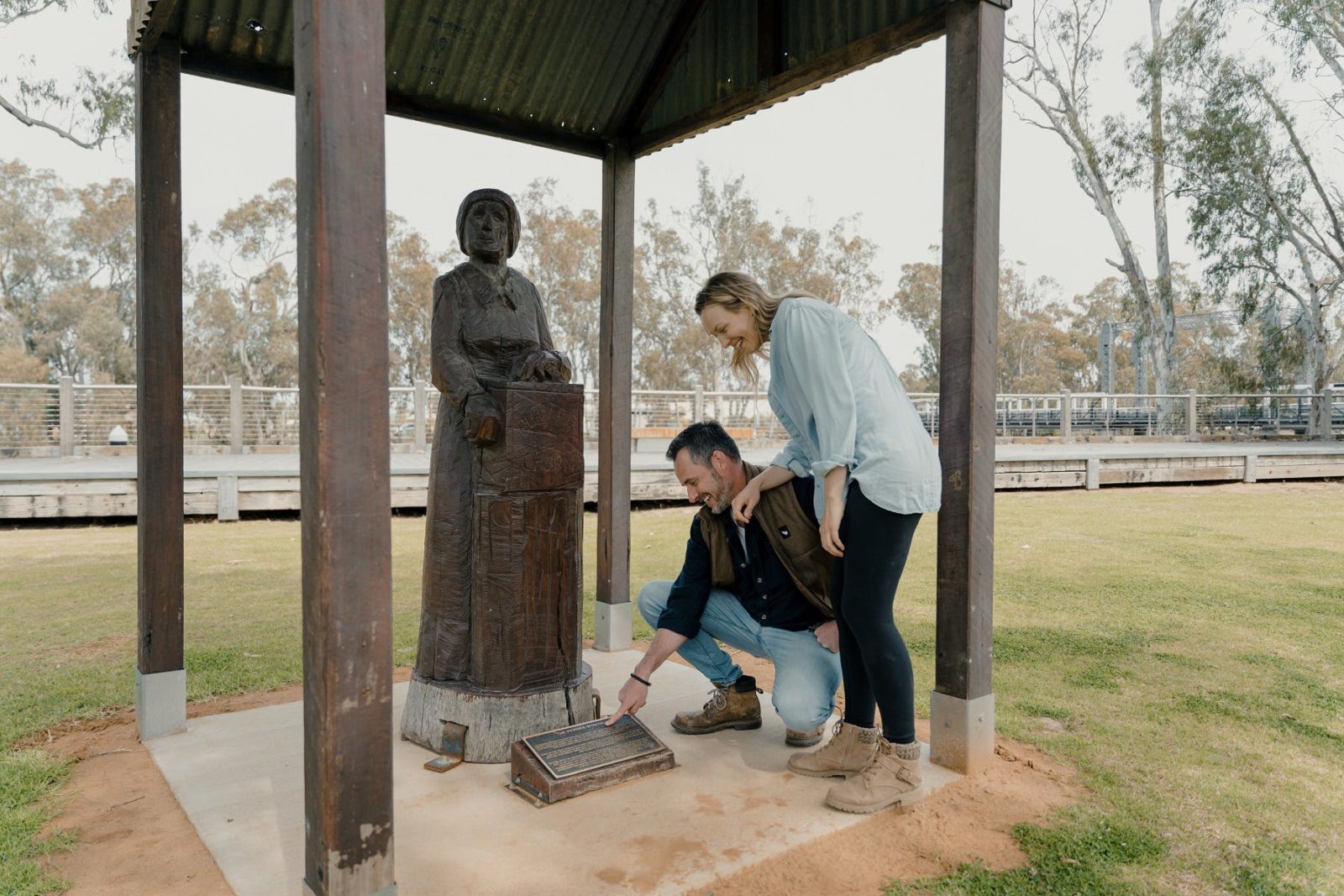 Couple viewing redgum statue