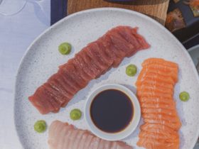 Tuna, Salmon, Kingfish sashimi on white plate with soy sauce and wasabi
