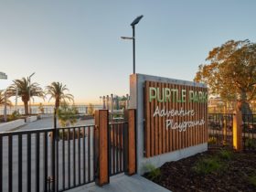 A fence and gate leading to a playground. A sign reads "Purtle Park Adventure Playground".