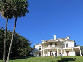 People walking up the grand lawn to Carrara House on Strickland Estate in Sydney Harbour National