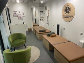 Photo shows stretch therapy beds, reception desk and seating area inside our studio.