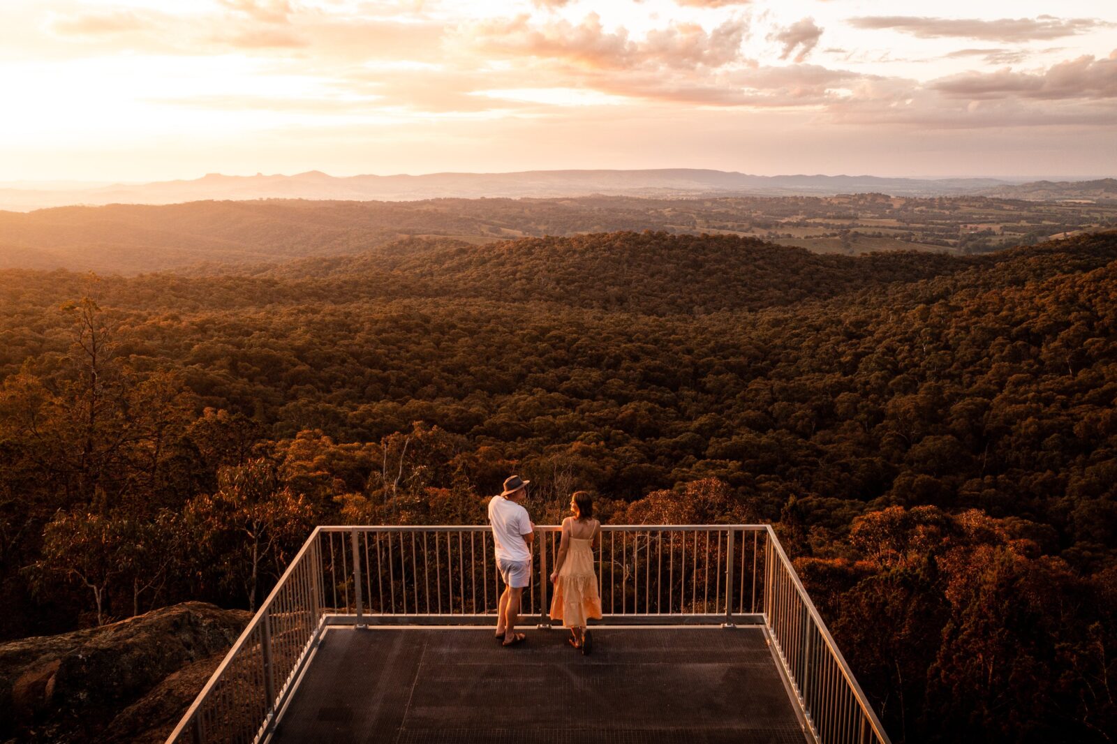 Drone photo of Yambla Lookout taken at sunset with a couple standing on the platform looking out.