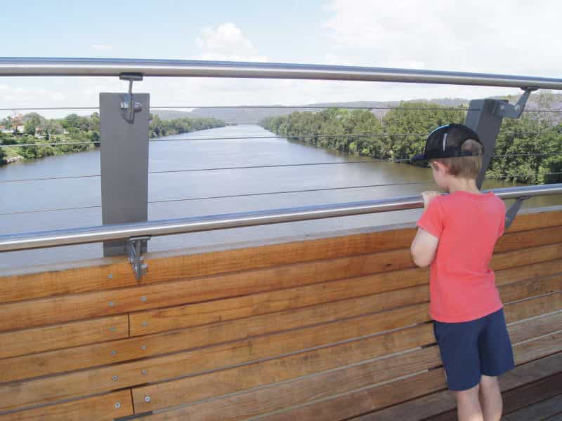 Boy looking over edge of bridge at Nepean River