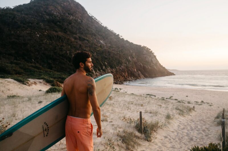 Man heading out to a morning surf at Zenith Beach, Port Stephens