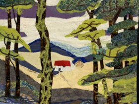 A landscape done in textiles of a creek, small house and mountains surrounded by trees.