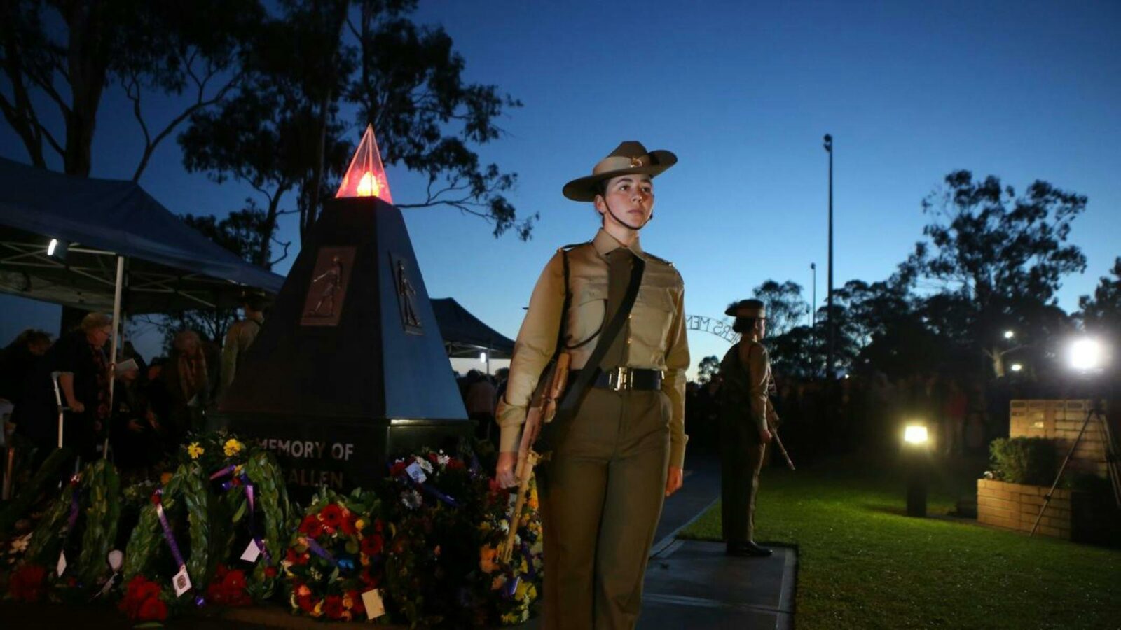 An image of a female soldier next to a cenotaph