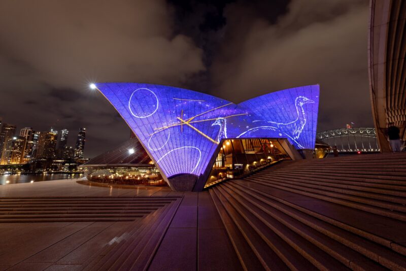 Bennelong sails illuminated with white line drawings on a blue background