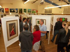 Wentworth Falls School Hall used as an art gallery. Art is displayed on Art Boards & adults browsing