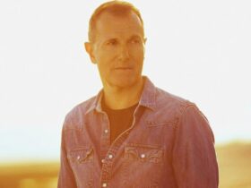 Close up of James Reyne standing outside looking to his left