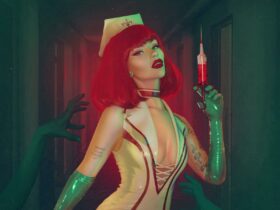 Woman with red hair in a nurse's outfit holding a syringe filled with red liquid