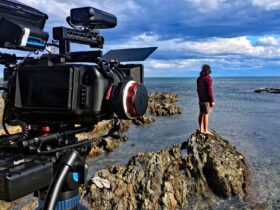 an indigenous man looks out to sea while being filmed for a documentary