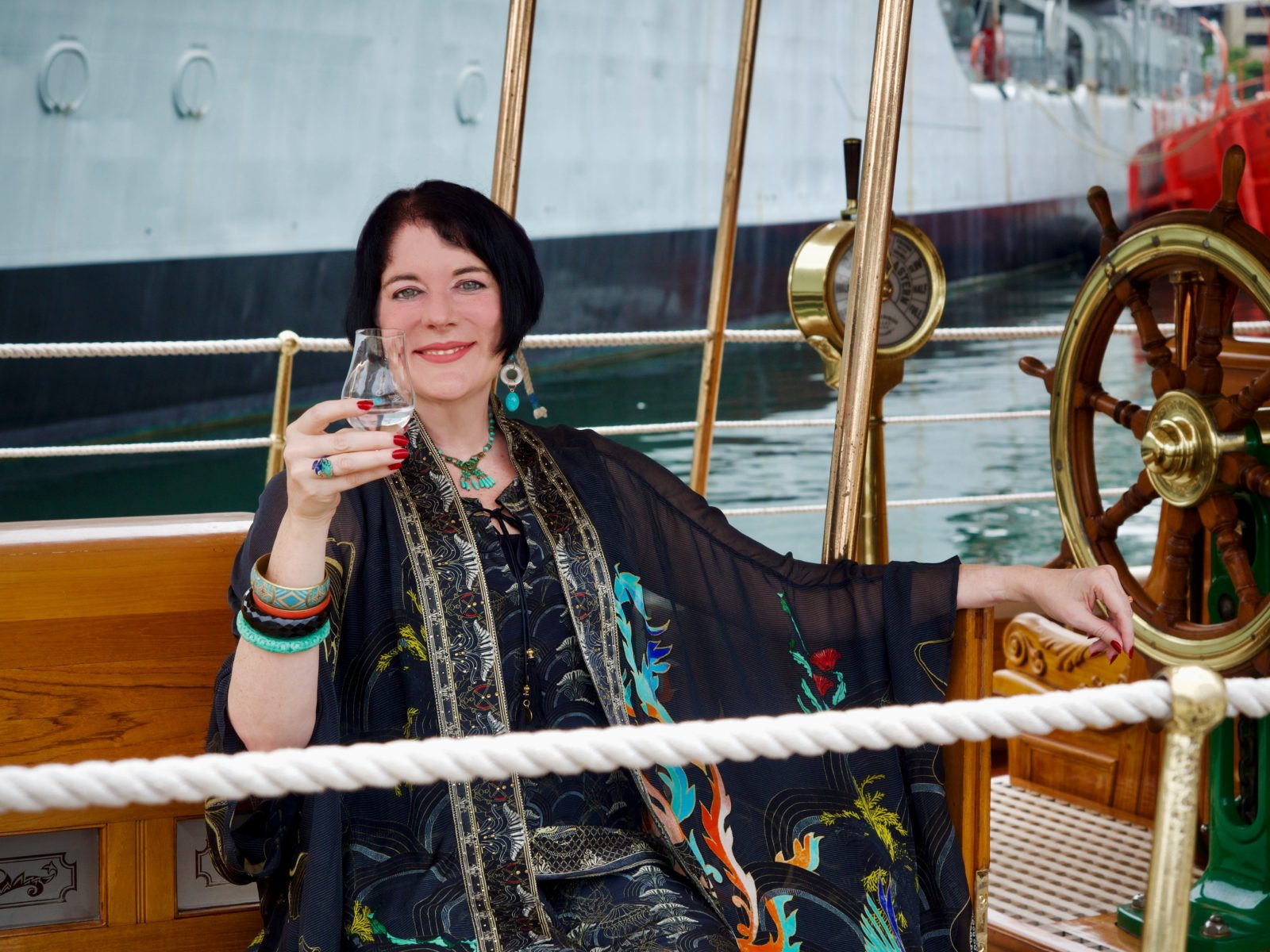 Woman reclining on a boat with a gin in hand