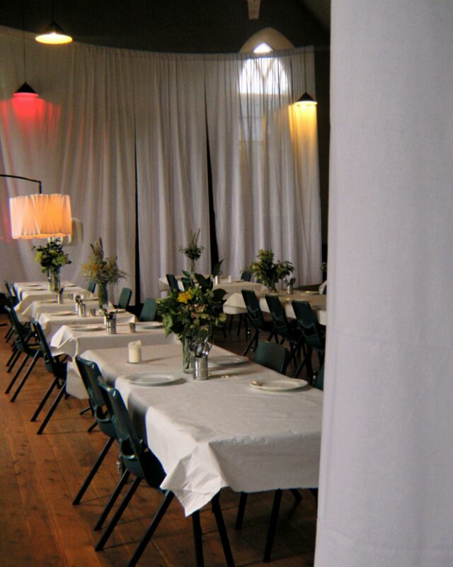 Restaurant setting with tables, chairs, flowers and lighting