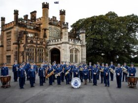 The NSW Police band congregated in front of a large castle in uniform