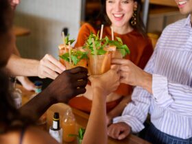 Group of people cheers their newly made orange cocktails