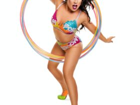 A woman in a sparkly costume steps through some hula hoops.