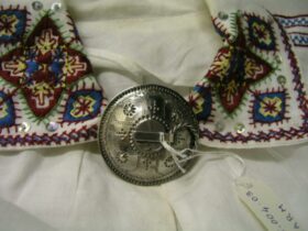 image of traditional brooch on traditional white embroidered dress