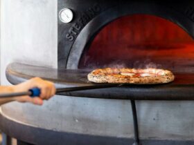 Woodfired pizza coming out of oven