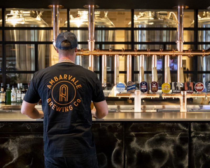 Bartender at Ambarvale Brewing Co wearing merchandise shirt
