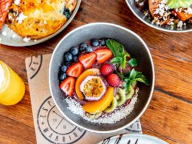 A table full of breakfast foods like an acai bowl and toast