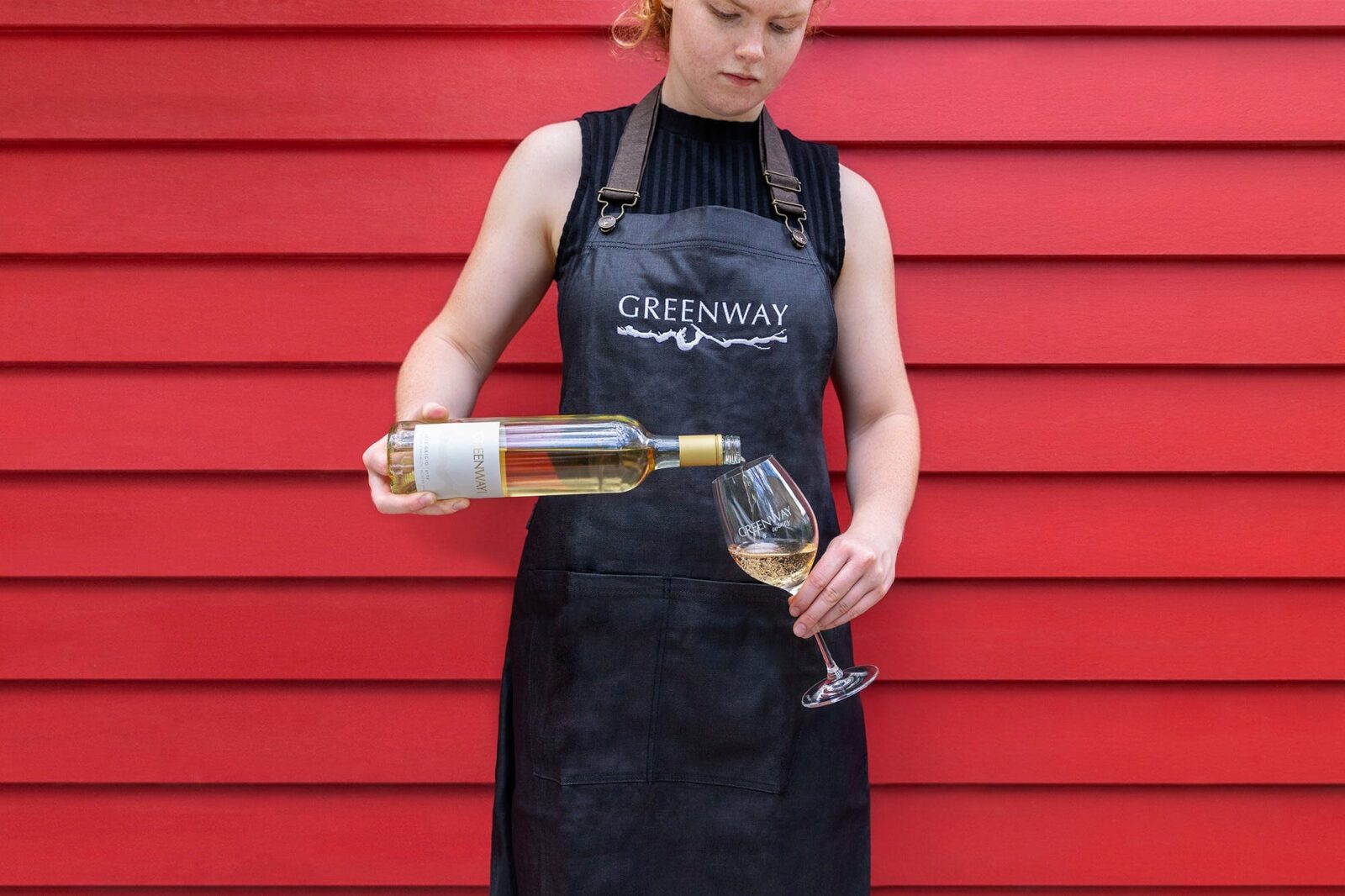 A Greenway Wines team member is pouring a glass of delicate pinot grigio