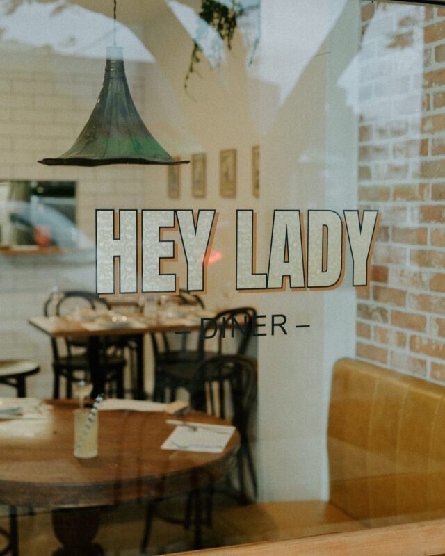 A view of the diner through the front window with Hey Lady text