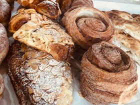 A table full of almond croissants and other pastries