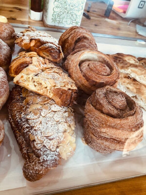 A table full of almond croissants and other pastries