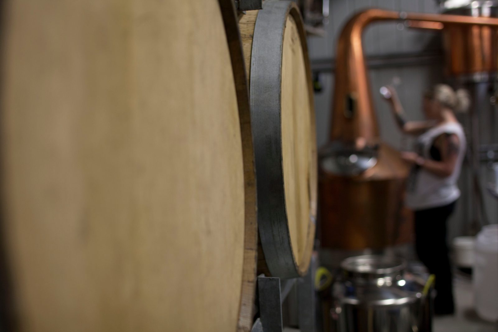 Rum barrels in the foreground with Ally distilling in the background.